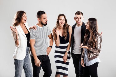 Kızlar ve çocuklar moda rahat kıyafetler içinde şirket konuşmak stüdyoda beyaz bir arka plan üzerinde