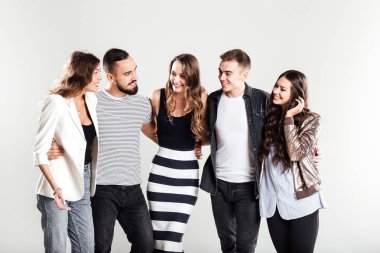 Kızlar ve çocuklar moda rahat kıyafetler içinde şirket konuşmak stüdyoda beyaz bir arka plan üzerinde