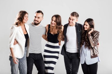 Kızlar ve çocuklar moda rahat kıyafetler içinde şirket konuşmak stüdyoda beyaz bir arka plan üzerinde