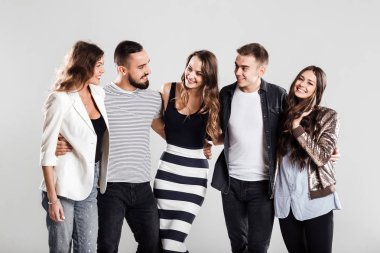 Casual Modern giyimleri arkadaş şirket yan yana ve stüdyoda beyaz bir arka plan üzerinde konuşmak
