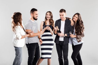 Casual Modern giyimleri arkadaş şirket yan yana ve gülümse. Adam bir şişe şampanya açar