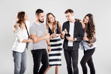Casual Modern giyimleri arkadaş şirket yan yana ve gülümse. Adam bir şişe şampanya açar