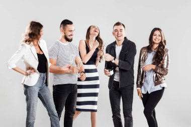 Casual Modern giyimleri arkadaş şirket yan yana ve gülümse. Adam bir şişe şampanya açar