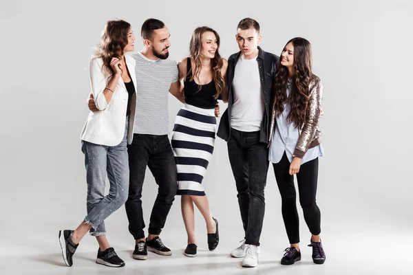 Εταιρεία των φίλων της μόδας casual ρούχα ενωμένοι και να μιλήσουμε για ένα λευκό φόντο στο στούντιο — Φωτογραφία Αρχείου