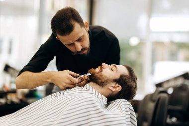 Kırmızı papyon ile siyah bir gömlek giymiş bıyıklı Moda kuaför berber mens sakallı kırpar