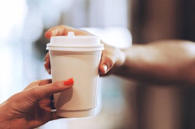 Bir ziyaretçi popüler bir kafede kahve barista geçirir, el ve bir bardak kahve yakın çekim çekim.