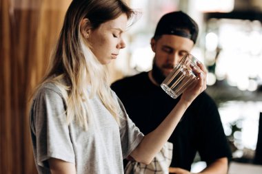 Rahat tarzı, giyen iki genç dostu barista stading birbirine yakın olan ve rahat bir kafede cam bakmak.
