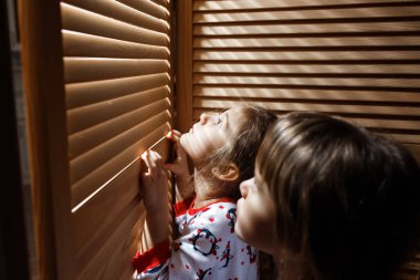 İki küçük kız içinde pijama giymiş ahşap kapı ile dolap gizleme