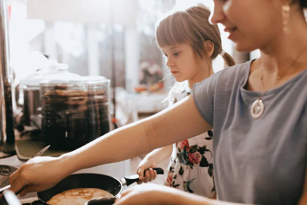 Матір з донькою мало приготування млинців на сніданок маленьких затишних кухні — стокове фото