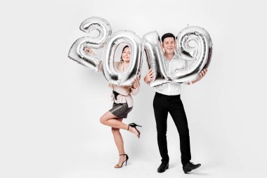 Komik kız ve bir şık akıllı giysiler giymiş adam balon numaraları 2019 stüdyoda beyaz bir arka plan üzerinde şeklinde tutuyorsun