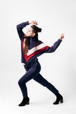 Kırmızı ve beyaz bir kazak ve topuklu pozlar stüdyoda beyaz zemin üzerine üzerine baskı ile sportif mavi elbiseli güzel kız giyinmiş