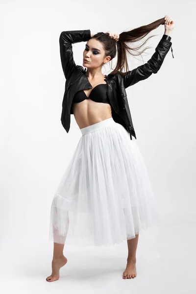 Premium Photo  Stylish dark-haired girl dressed in a black t-shirt, shorts,  tights and cap is posing on the white background in the studio .