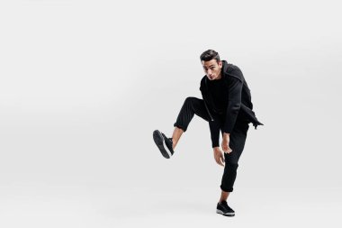 Genç adam bir şık siyah elbise giymiş bir bacak sokak dansı dans ederken kaldırıncaya