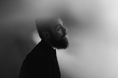 Siyah ve beyaz fotoğraf portre profil sis siyah gömlek giymiş bir sakal ile şık bir adamın