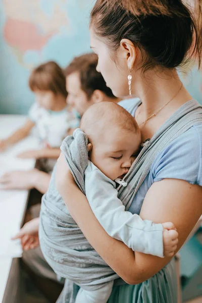 Anne baba küçük kızı ile harita üzerinde duvar odadaki masasında bir ders yapmak için yardımcı olurken bir bebek tutan — Stok fotoğraf