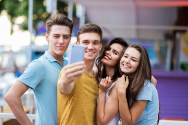 Yakışıklı arkadaş bir şirket gülüyor ve selfie güzel yaz kafede yapma. Eğlence, iyi vakit geçiriyor. Dostluk.