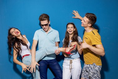 Dört yakışıklı arkadaş kendinden emin ve mutlu görünüyor sahip mavi duvar önünde dururken gülüyorlar. Eğlence, iyi vakit geçiriyor. Dostluk, ilişki.