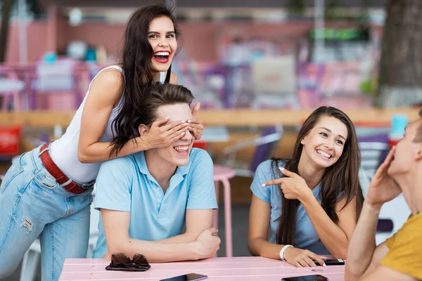 Eine Gruppe gut aussehender Freunde sitzt lachend am Tisch im netten Sommercafé. Unterhaltung, Spaß haben. Freundschaft. — Stockfoto