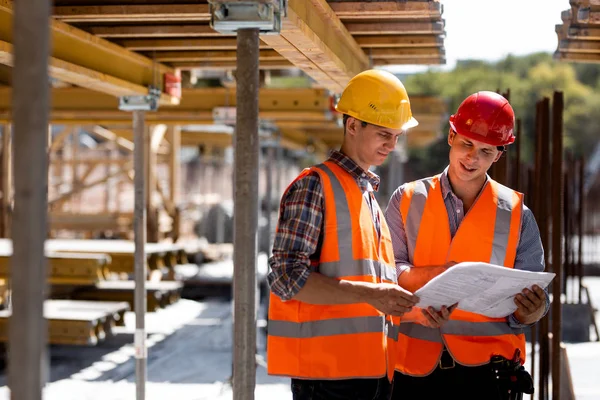 Två Civilingenjörer Klädd Orange Arbete Västar Och Hjälmar Utforska Konstruktion — Stockfoto