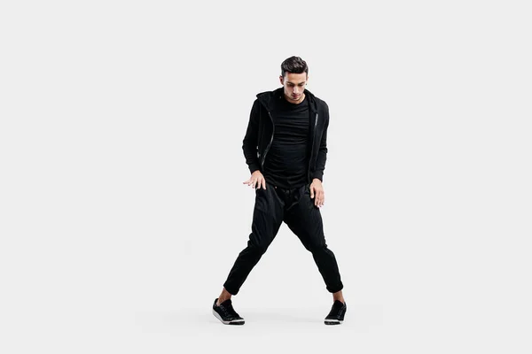 Beau jeune homme portant un sweat noir et un pantalon noir danse breakdance — Photo