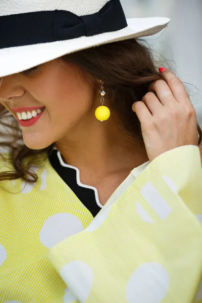 Портрет усміхненої дівчини брюнетки в капелюсі і жовтого в білому горошині блюз — стокове фото