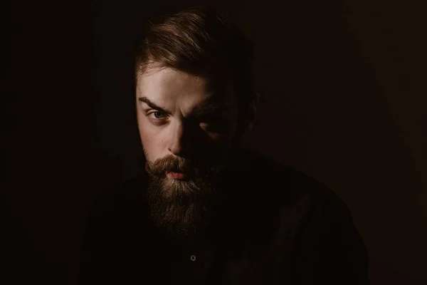 Sepia retrato de um homem elegante com uma barba e penteado elegante vestido com a camisa preta no fundo escuro — Fotografia de Stock