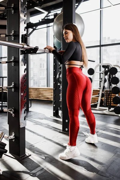 세련 된 밝은 스포츠 옷에 날씬한 여자 현대적인 체육관에서 주위 스포츠 장비와 수평 막대 옆에 서 있는 포즈 — 스톡 사진