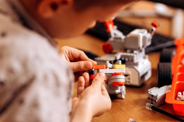 Akıllı çocuk gri gömlek giymiş bir robot Robotik okul masasında robot Oluşturucu yapar