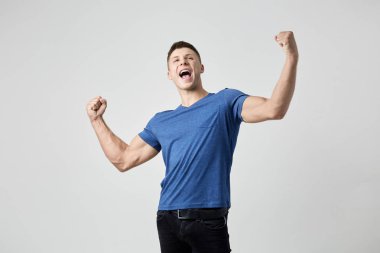 Mavi t-shirt giymiş adam güç ve enerji dolu hissediyorum. Beyaz arka plan üzerinde atış stüdyo