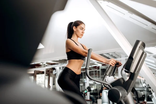 Esmer atletik kız siyah spor top ve tayt yoluna spor salonunda bir koşu bandı üzerinde giyinmiş. — Stok fotoğraf