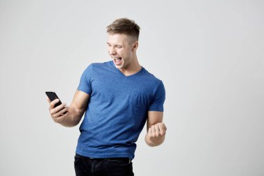 Kendinden geçmiş adam mavi t-shirt giymiş onun cep telefonu görünüyor