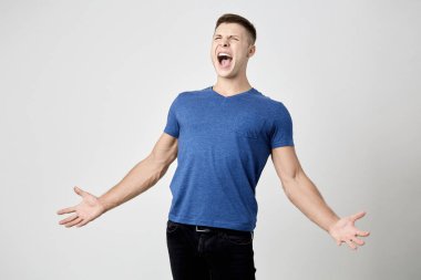 Mavi t-shirt giymiş kendinden geçmiş adam bağırıyor