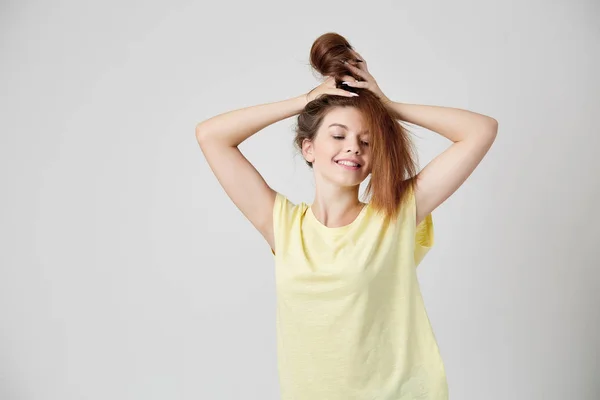 Menina de t-shirt amarela brincando com o cabelo — Fotografia de Stock