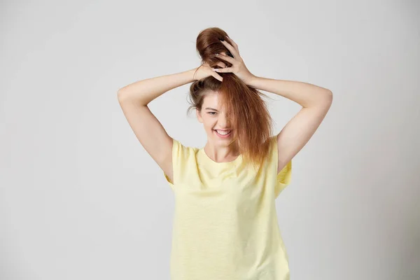 Menina de t-shirt amarela brincando com o cabelo — Fotografia de Stock