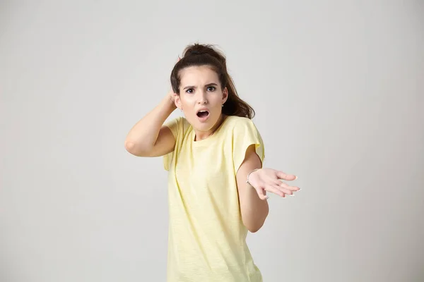 Förvånad tjej klädd i gul t-shirt — Stockfoto