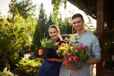 Bahçers mutlu çocuk ve kız sıcak güneşli bir gün güzel bahçelerin bitkiler ile tencere tutun