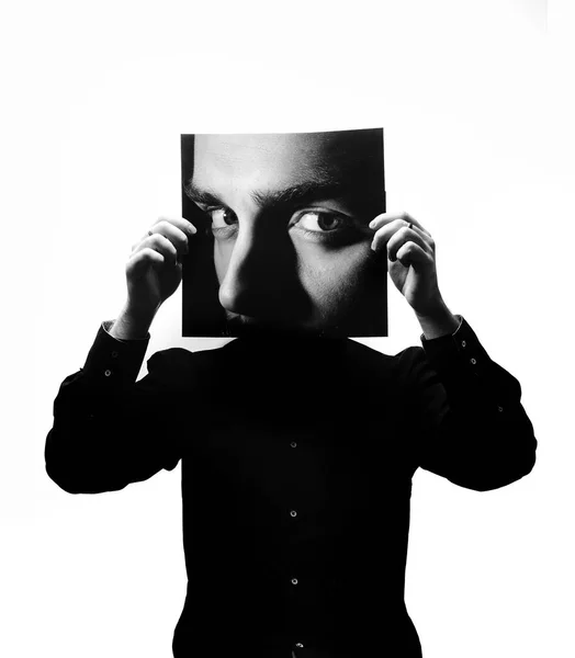 Foto in bianco e nero dell'uomo in camicia nera con in mano una foto con il volto di un uomo al posto del suo volto — Foto Stock