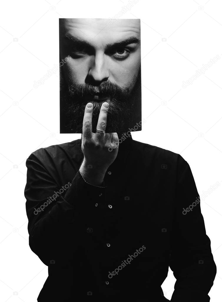 Black and white photo of man in the black shirt holding a photo with the face of a man with a beard in place of his face