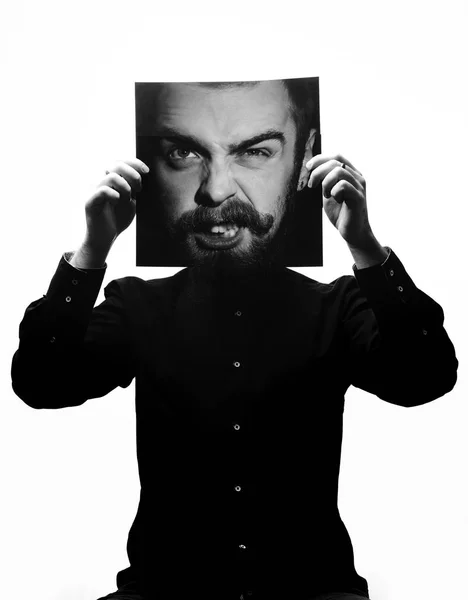 Foto em preto e branco do homem com a camisa preta segurando uma foto com o rosto de um homem com barba no lugar do rosto. Multiexposição — Fotografia de Stock