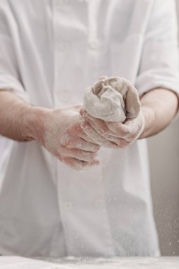 Profesyonel fırıncı fırının mutfağında elinde hamur yoğuruyor