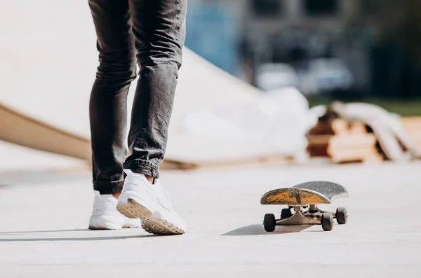 Der Mann fährt an dem sonnigen, warmen Tag auf einem Podest neben dem Haus Skateboard — Stockfoto