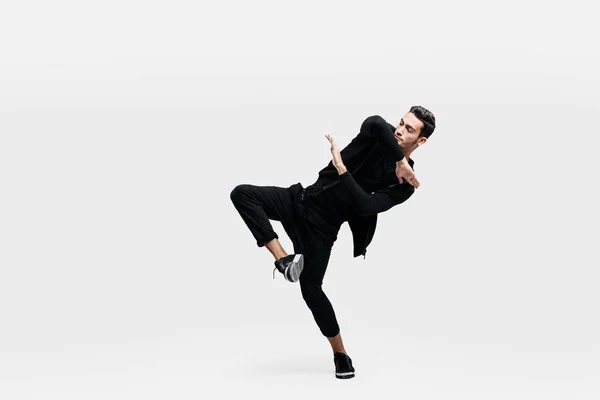 Jovem elegante vestindo uma camisola preta e calças pretas faz movimentos estilizados de hip-poh — Fotografia de Stock