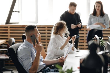 Modern ofis ekipmanları ile donatılmış ışık modern ofiste genç başarılı bir ekibin personel toplantısı