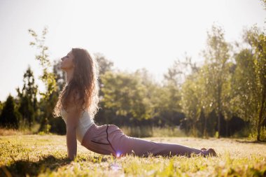 Yoga giysileri genç kadın güneşli gün çim üzerinde doğada açık havada Yoga pratik