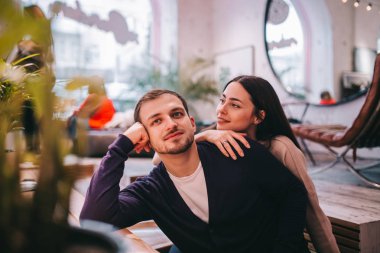 Sevgi dolu kız rahat romantik kafede masada oturan erkek arkadaşının omzunda elini tutar