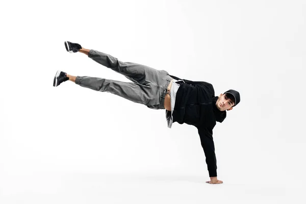 Jovem dançarina elegante está dançando breakdance. Ele está de pé em um braço e levantando ambas as pernas para cima . — Fotografia de Stock