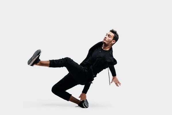 Bonito jovem dançarino vestindo uma camisola preta e calças pretas está dançando breakdance — Fotografia de Stock