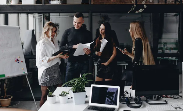 Jeune équipe travaille avec des documents et discuter du projet dans un bureau moderne élégant. Processus de travail au bureau . — Photo