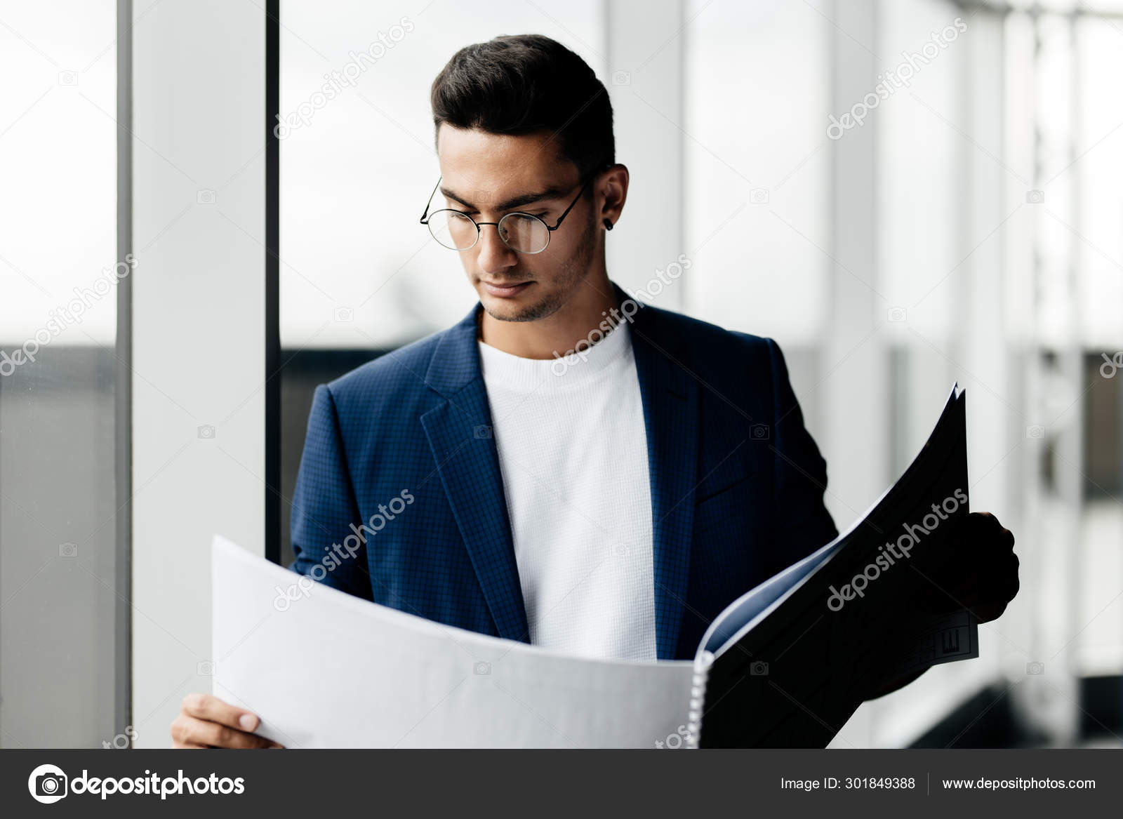 Architect dressed in stylish clothes stands next to window and explores the  sheet with drawing in his hands Stock Photo by ©Leika_production 301849388