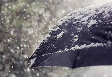 Kötü hava, kış veya kar yağıyordu blizzard için Siyah şemsiye konsept üzerine düşen kar pul